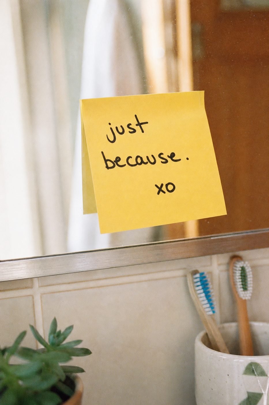 A sticky note on the mirror that says just because
